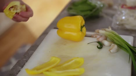 mujer sacando un pimiento en la tabla de cortar en cámara lenta