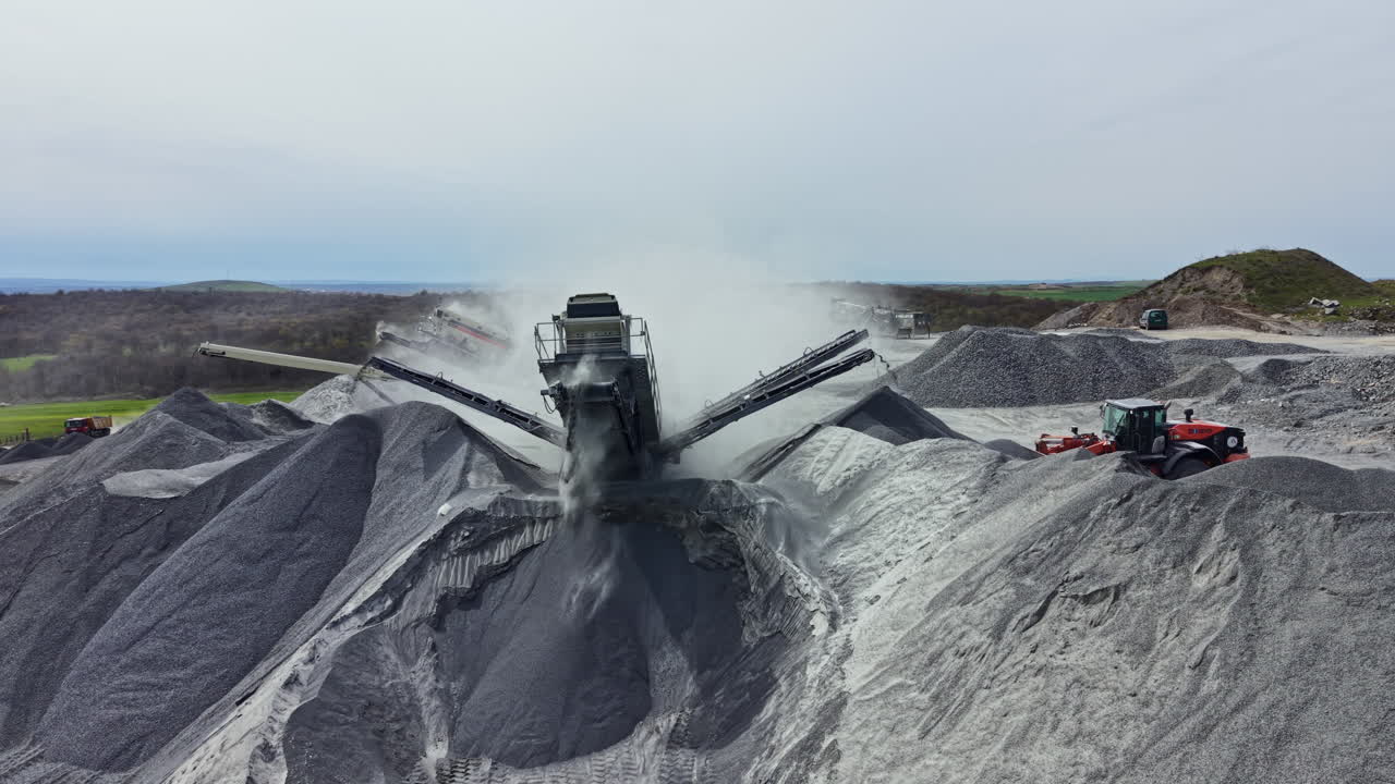 Granite quarry operation with equipment working on stone piles at a site in nature during the day