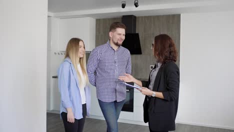 man and woman interacting with real estate agent while watching the apartment for rent or buy