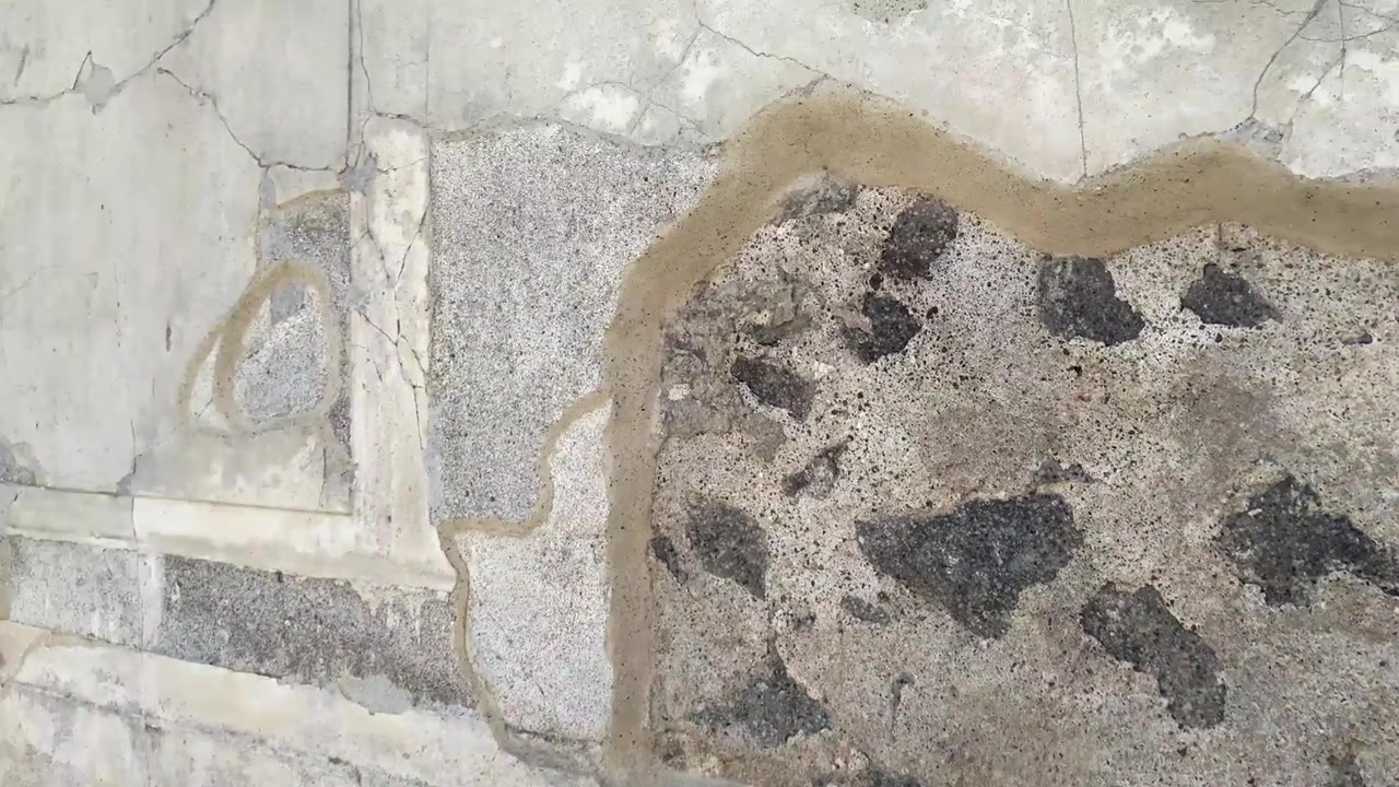 Close up detail of an ancient wall of the ruins of the city of Pompeii, with plaster and other ancient materials