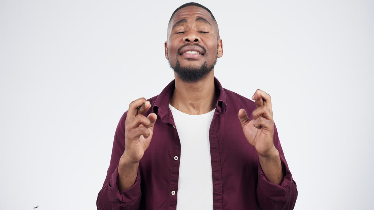 cara, dedos cruzados hombre negro en el estudio