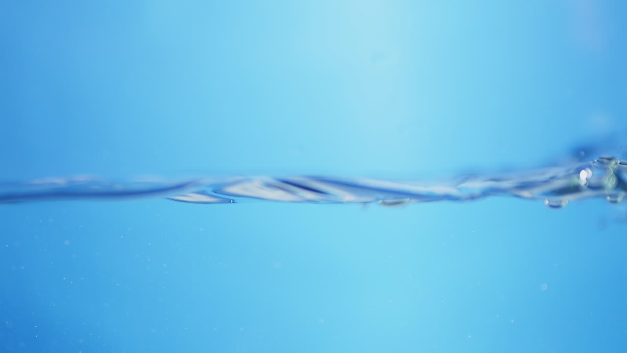 Breathtaking close-up of water in slow motion, capturing the beauty of blue waves and the purity of natural drinking water.