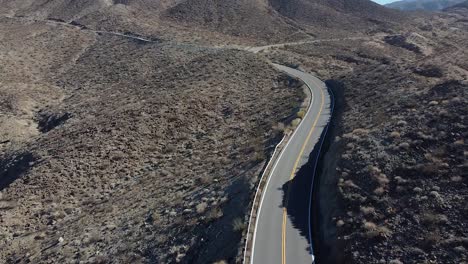 black car driving on desert road in california