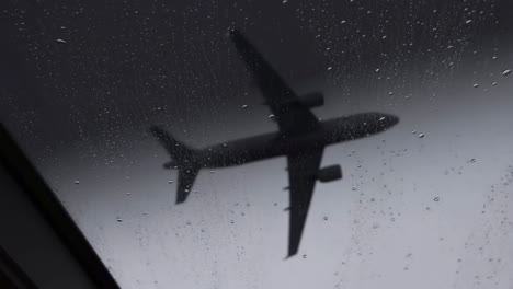 Airplane Silhouette Through Rain-Streaked Window