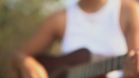 Blurry-slow-motion-background-woman-with-white-shirt-playing-a-guitar