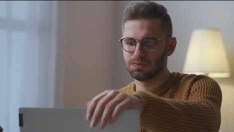 Männlicher-Benutzer-Schließt-Laptop-Und-Setzt-Brille-Nach-Dem-Arbeitstag-Zu-Hause-Ab-Mittleres-Porträt-Eines-Erschöpften-Mannes,-Der-Remote-Arbeit-Und-Freiberufliche-Arbeit-Verrichtet