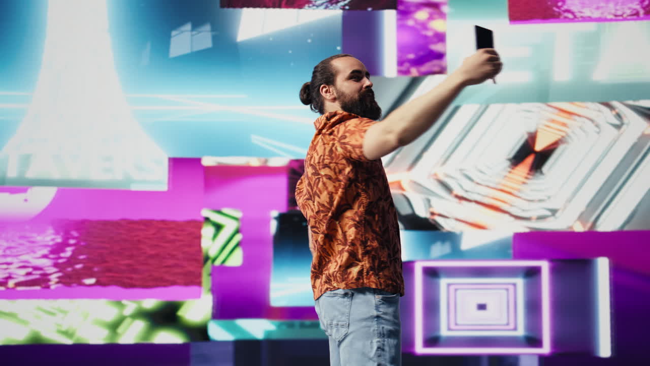 Cool relaxed guy using his smartphone under neon lights