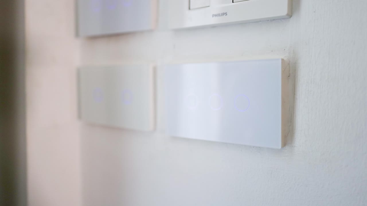 A close-up shot of a finger pressing buttons on a modern white touch control panel