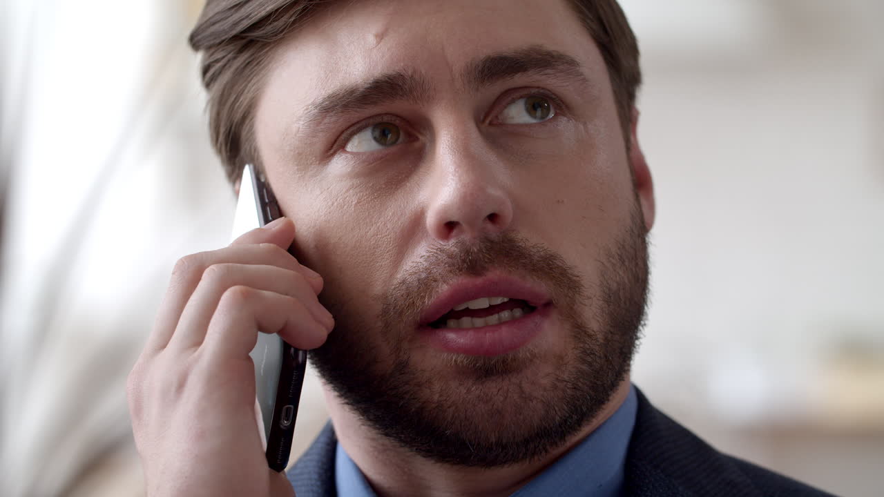 Focused business man talking on cellphone at home office. Guy speaking phone.