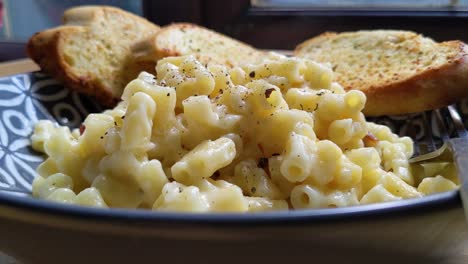 Plated-Macaroni-Cheese-with-Garlic-Bread-and-Cracked-Black-Pepper