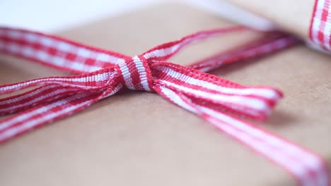 close up of wrapped gifts with red and white ribbon