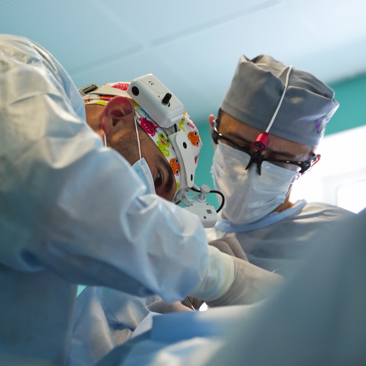 Lavoro meticoloso e accurato dei chirurghi durante l'operazione. Visuale dal basso verso l'alto di medici che eseguono l'intervento. Primo piano