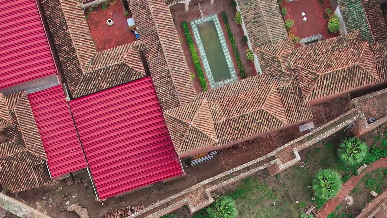 Historic walls and green space in Malaga Spain with red rooftops