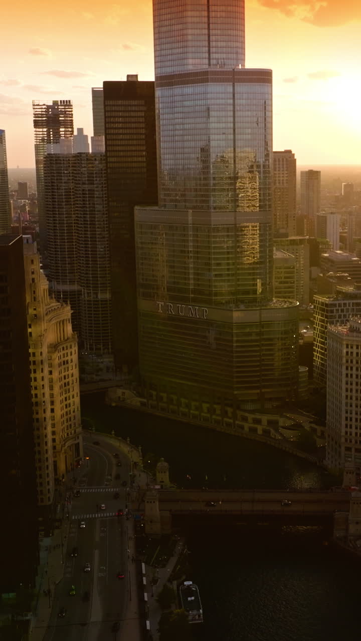 Chicago River in the city downtown. Darkening buildings of metropolis at coming evening. Yellow sky backdrop. Vertical video