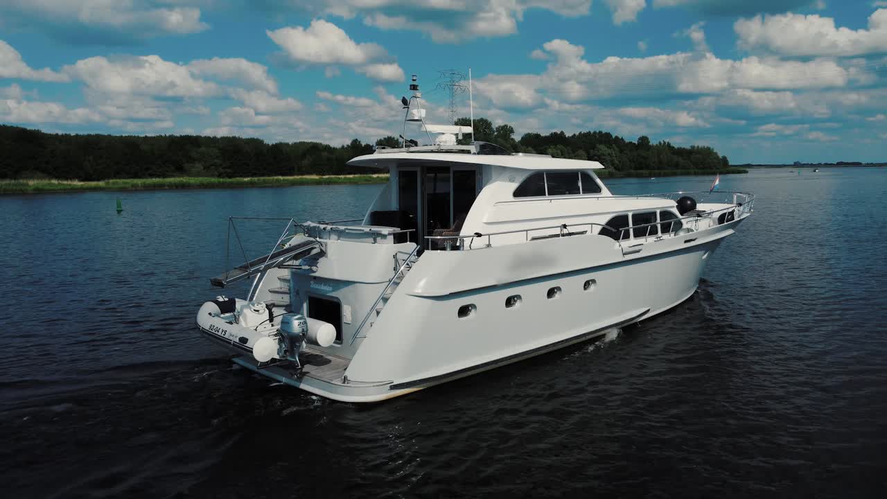 Lussuoso yacht bianco che naviga sull'acqua, vista da poppa.