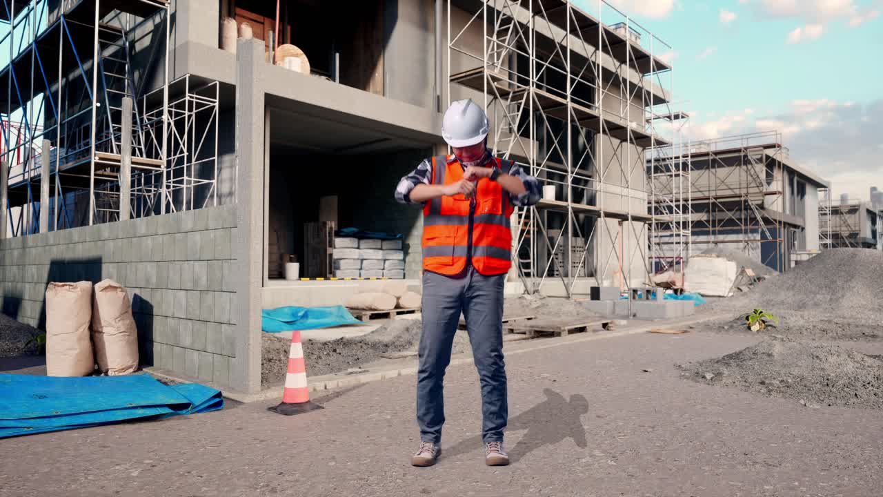 Full Body Of Asian Male Engineer With Safety Helmet Screaming Goal And Dancing Celebrating At Building & Construction Site in Progress to New House