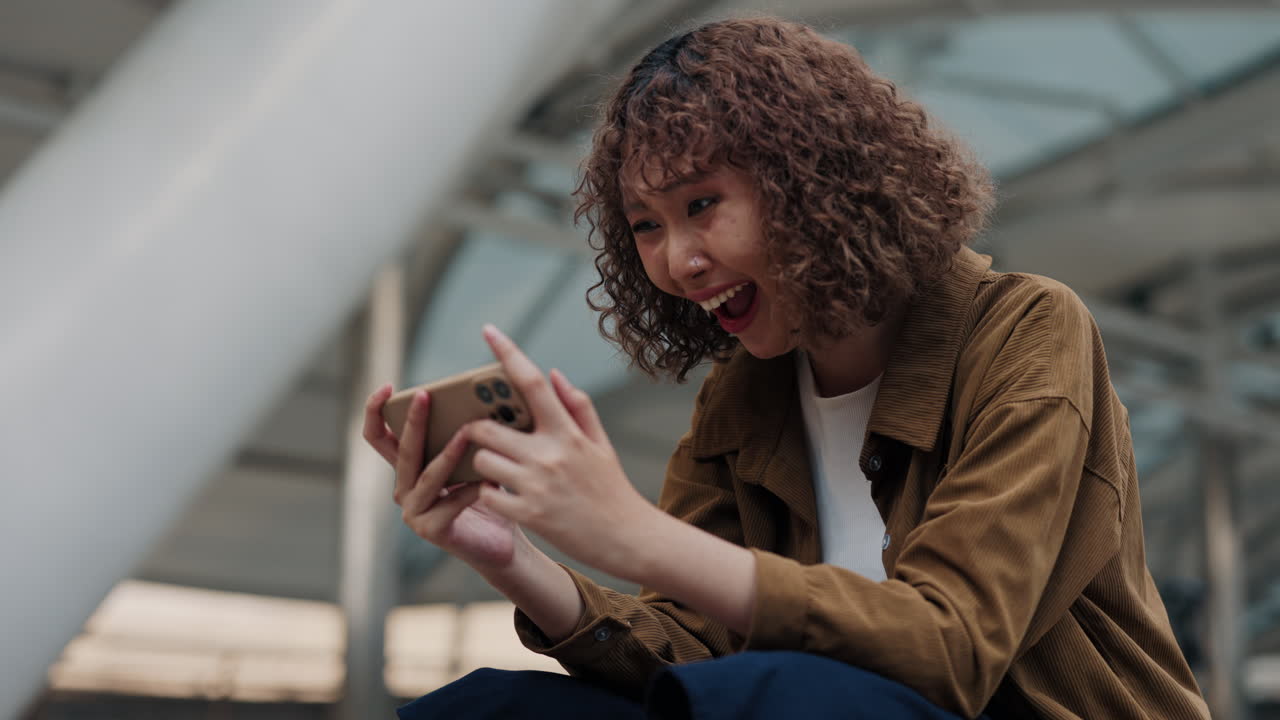 Happy Woman Playing a Game on Her Smartphone