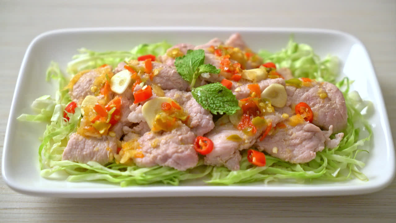 ensalada picante de cerdo o cerdo hervido con salsa de chile, ajo y lima.