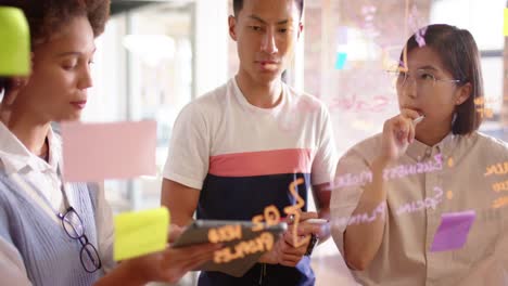 happy diverse male and female creative colleagues brainstorming ideas on glass wall, slow motion