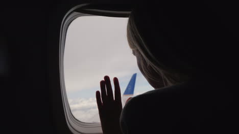 Silhouette-Of-A-Woman-Looking-Out-The-Window-Of-The-Plane-Back-View