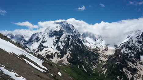 air flight through mountain clouds over beautiful snow-capped peaks of mountains and glaciers.