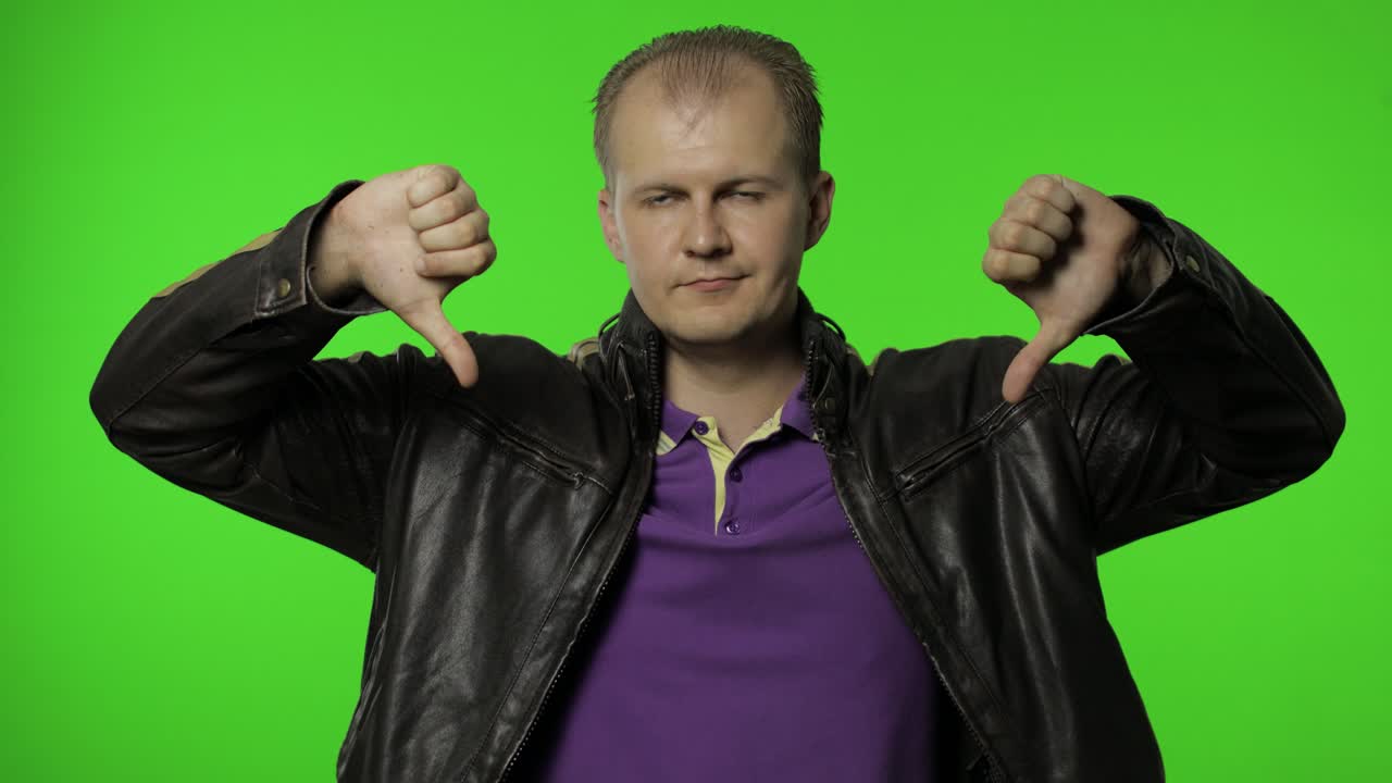 화가 난 남자는 두 개의 엄지손가락을 아래로 보여주고, "아니요, 좋아하지 않아요"라고 말하고, 나쁜 선택을 거부하고, 제스처를 싫어합니다.