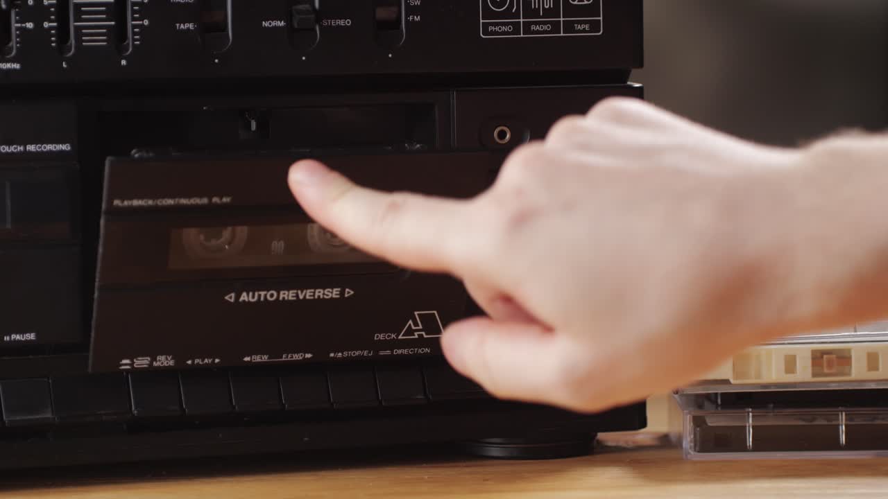 Retro radio tape recorder, audio cassette close-up. Listening to music, old radio boom box player, macro of vintage music listening.