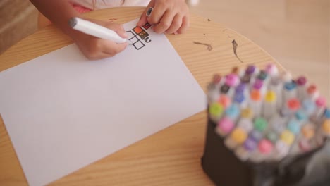 child drawing with markers on paper