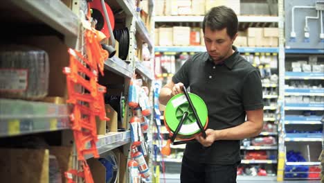 hombre comprando suministros eléctricos en una ferretería