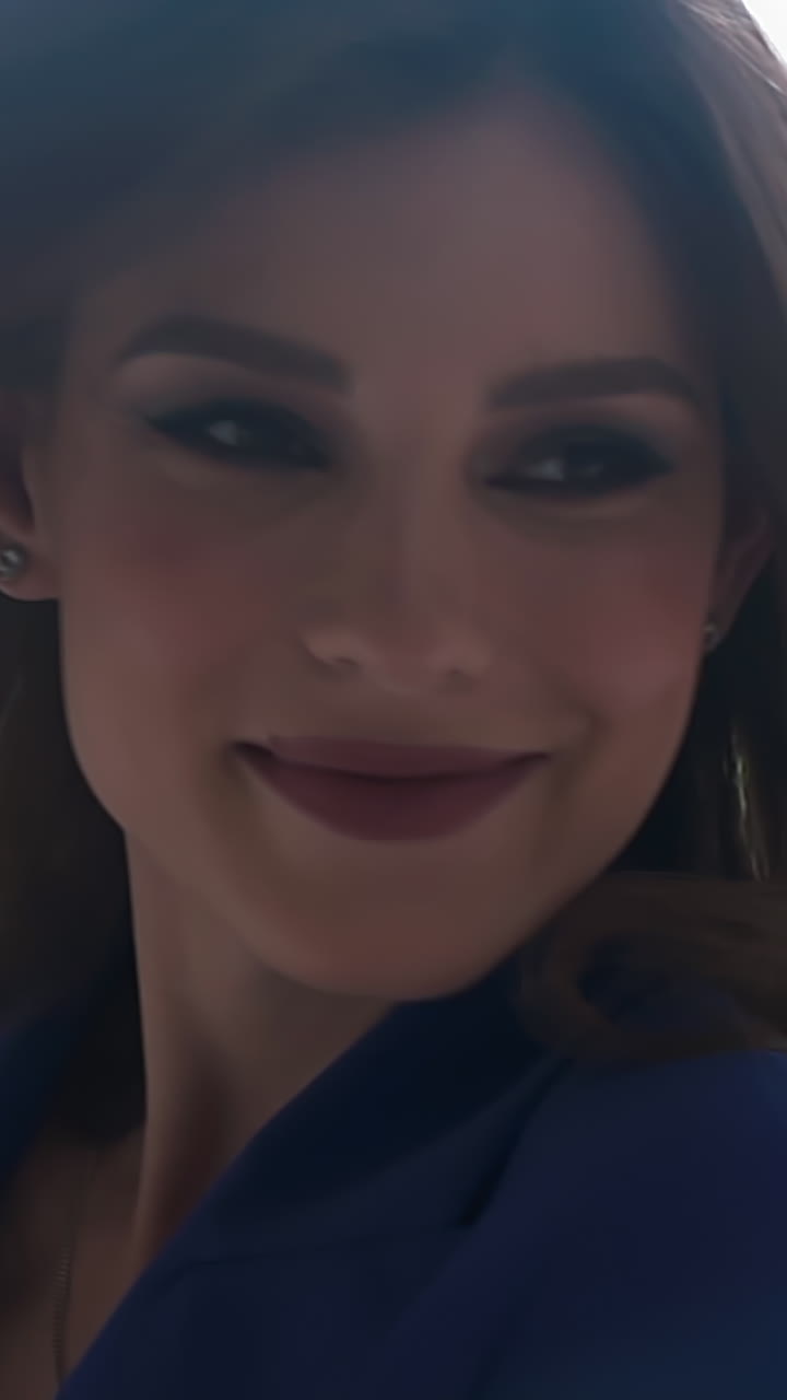 Pretty cheerful young woman turns around shaking long chestnut hair near open window in light spacious room on spring day extreme closeup slow motion