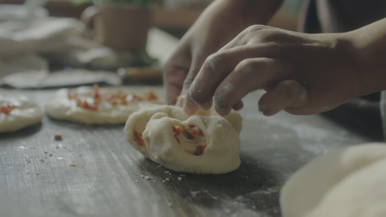 Close-up of hands shaping dough for baking