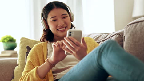 woman, headphones and phone in a living room