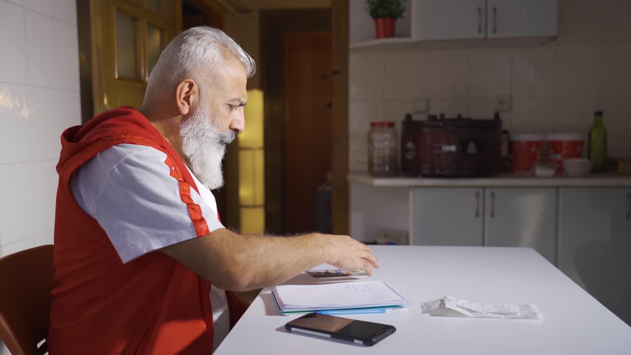 The poor man does financial calculations by looking at bills and has little money.