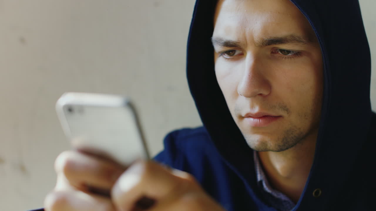 retrato de un joven muy cansado tratando de leer un mensaje en el concepto de teléfono problemas crimen