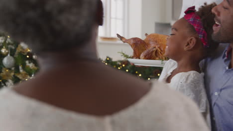 Familia-Multigeneracional-Celebrando-La-Navidad-En-Casa-Con-El-Abuelo-Sirviendo-Pavo