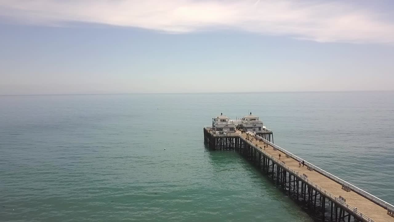 famoso muelle de alrededor de 1905 en la playa en verano mantecoso suave vista aérea vuelo volar hacia atrás imágenes de drones en la en malibu pier beach usa 2018