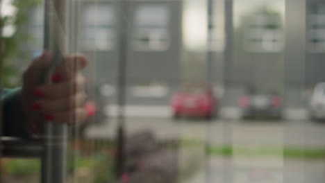 hand of elegant woman opening glass door of office building