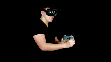 young man playing action video game in virtual reality, wearing vr goggles and holding controller