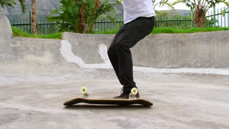 side view of young caucasian man practicing skateboarding trick on ramp in skateboard park 4k