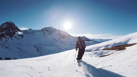 Zeitlupenansicht-Eines-Skifahrers,-Der-Anmutig-In-Den-Bergen-Ski-Fährt,-Mit-Wunderschönen-Sonnenstrahlen,-Die-Vor-Der-Wunderschönen-Bergkulisse-Im-Skigebiet-Der-Französischen-Alpen-Leuchten