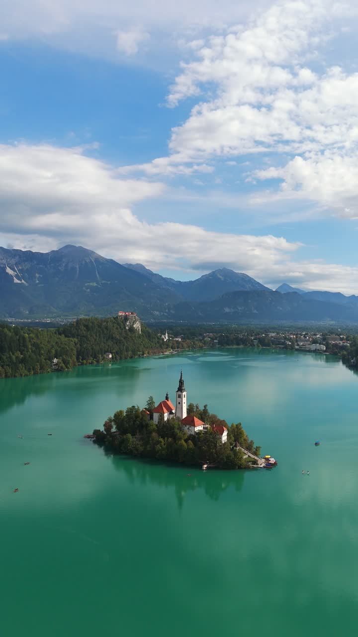 Vertical Shot Of Lake Bled Island With Bled Castle In The Distance In Slovenia