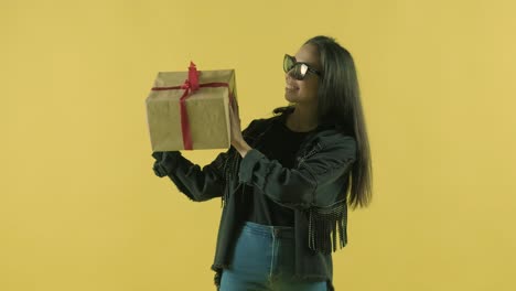 happy girl with a gift box. yellow background