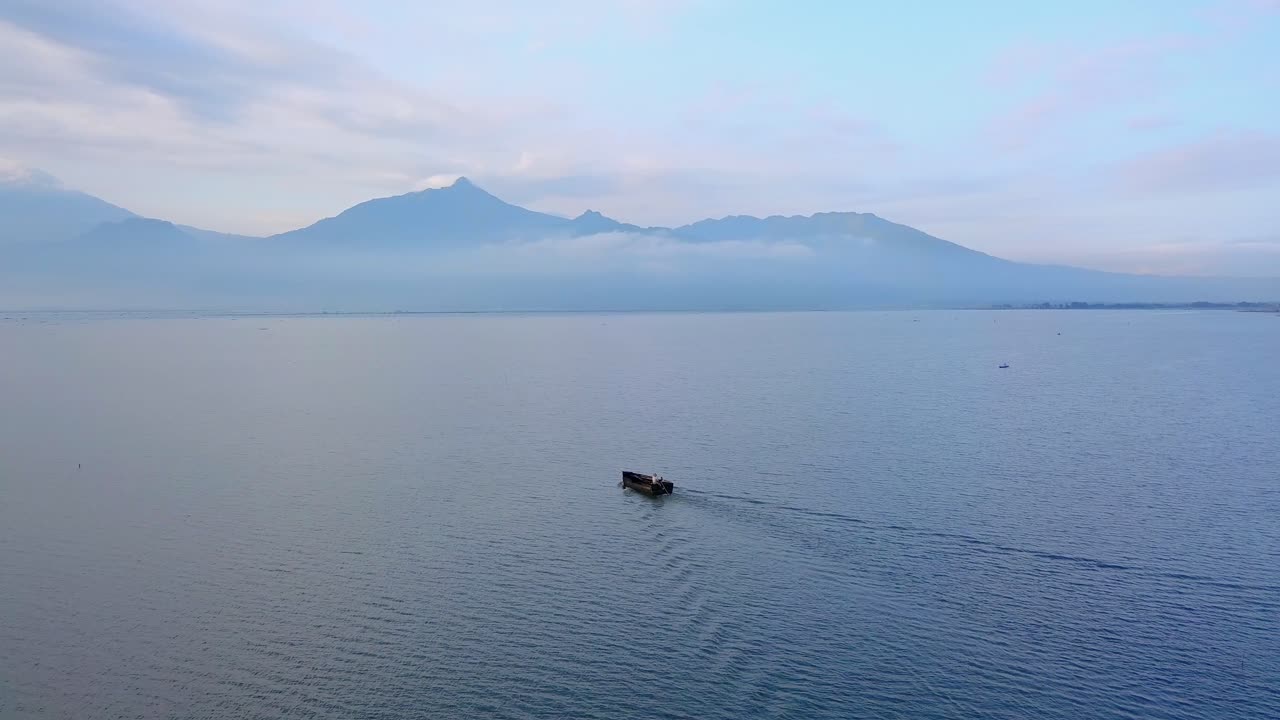 barco pesquero asiático de madera navegando en el lago por la mañana - lago rawa pening