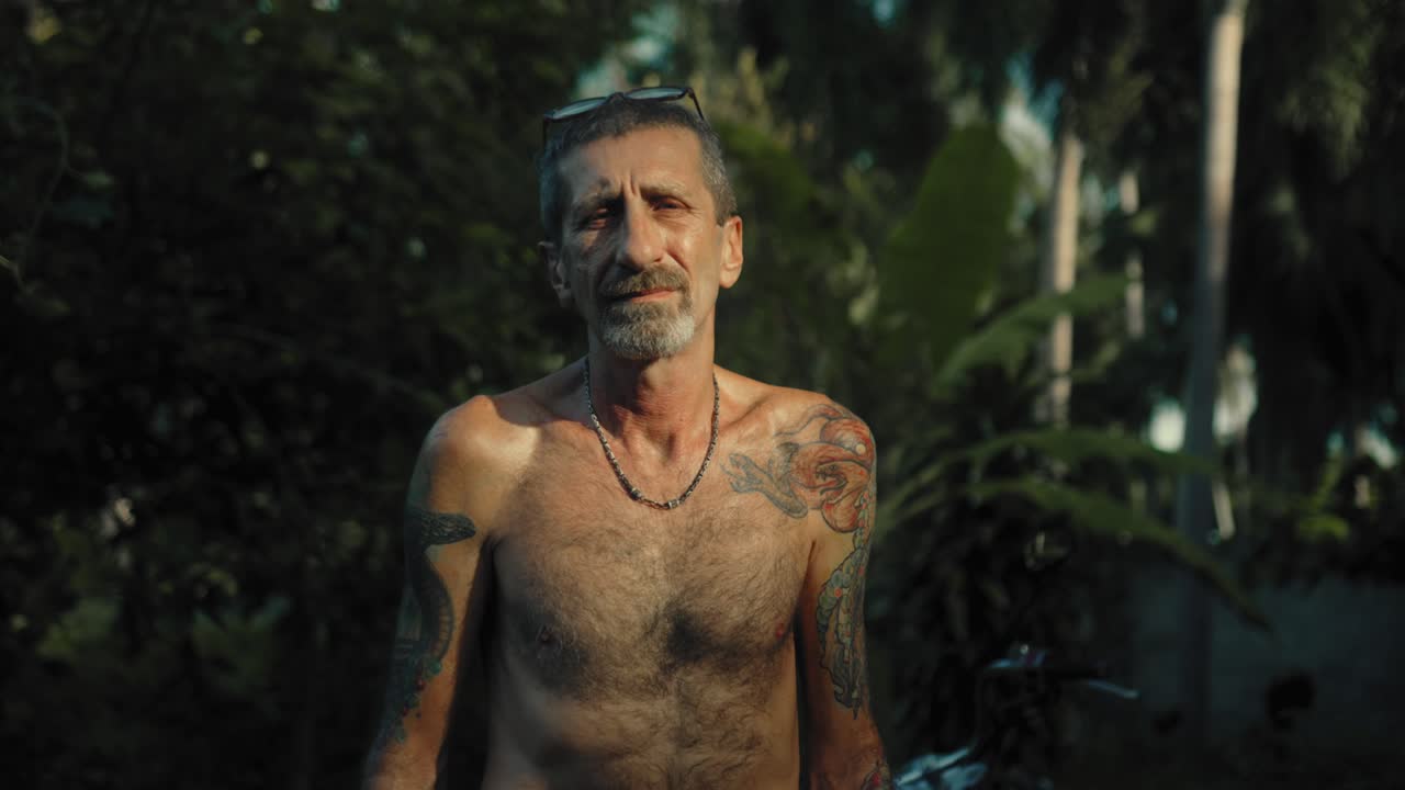 Man with tattoos in a tropical setting