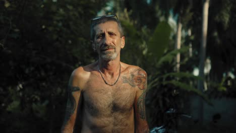 man with tattoos in a tropical setting