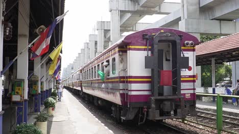 conductor putting a green flag out of the train in bangkok