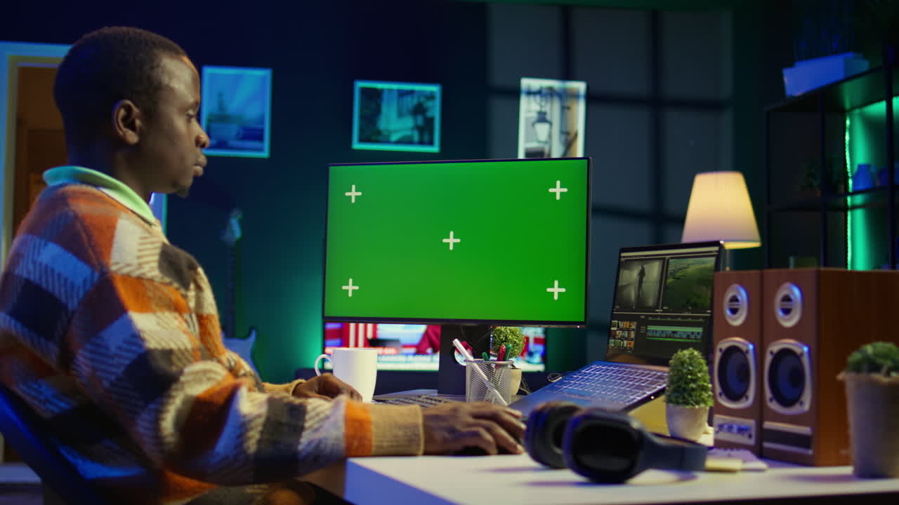Uomo che lavora al computer con schermo verde nell'ufficio di casa
