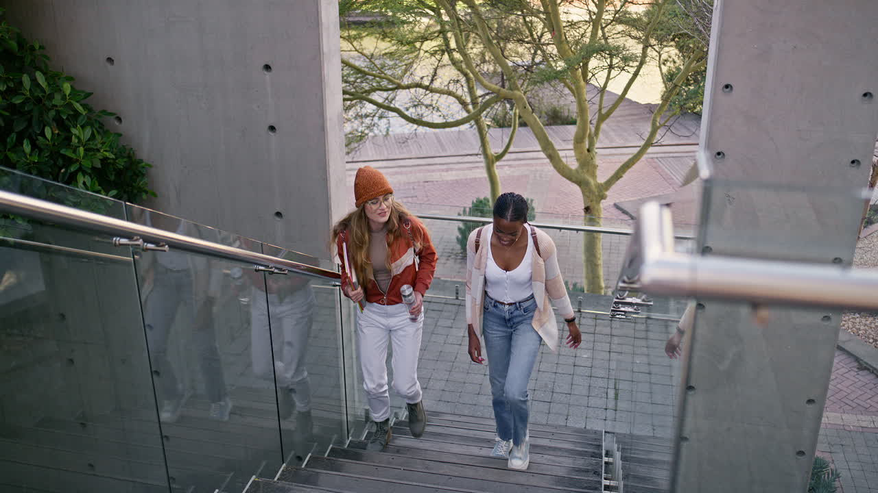 Two female students walking up outdoor stairs