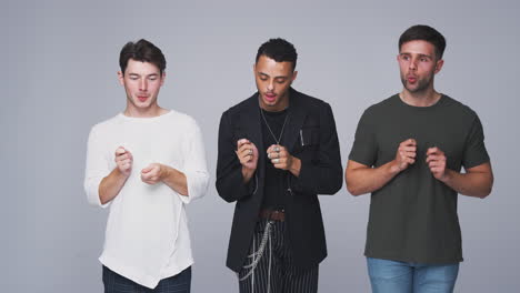 group studio portrait of multi-cultural male friends dancing in slow motion together