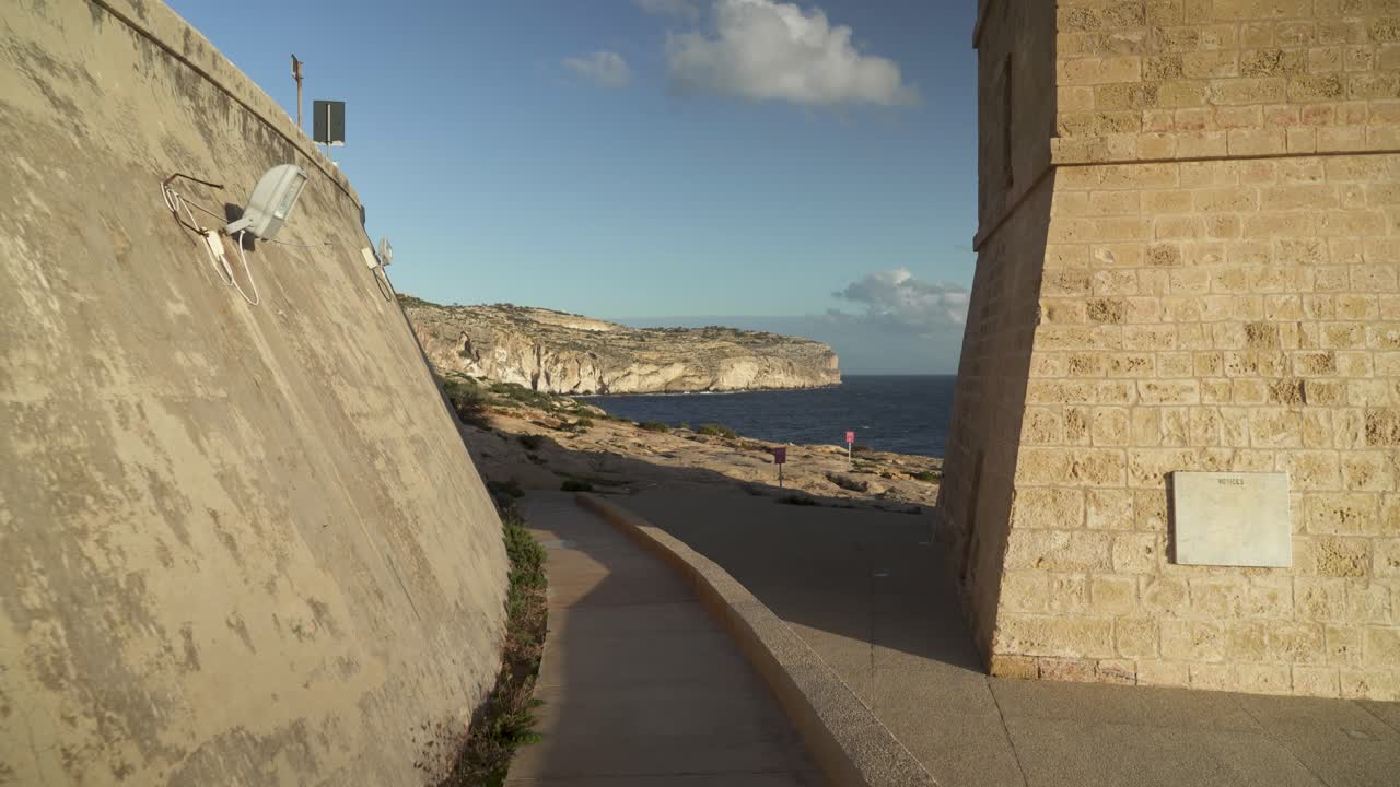 Torre di pietra e strada che conduce alla Grotta Azzurra durante l'ora d'oro serale a Malta